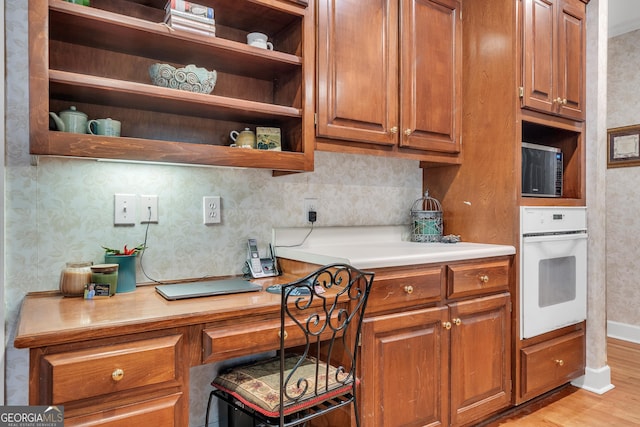 kitchen featuring brown cabinets, open shelves, and white oven