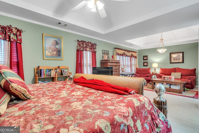 carpeted bedroom featuring visible vents, a raised ceiling, ornamental molding, a ceiling fan, and a skylight