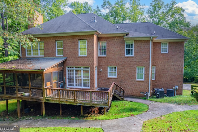 rear view of house with brick siding, central air condition unit, and a sunroom