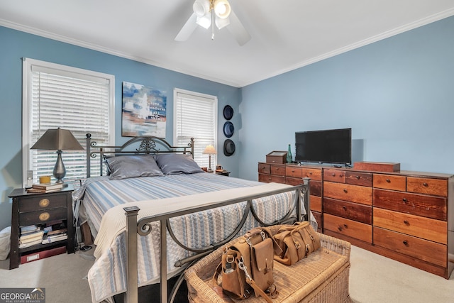 carpeted bedroom featuring crown molding and a ceiling fan