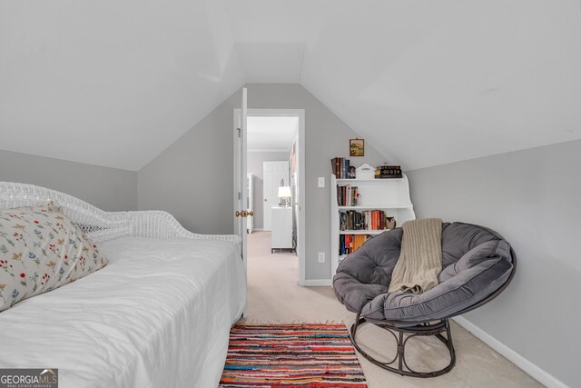 bedroom featuring light colored carpet, baseboards, and lofted ceiling