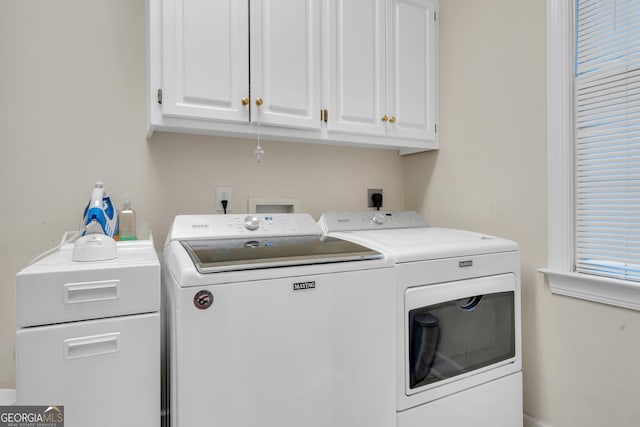clothes washing area with washer and dryer and cabinet space