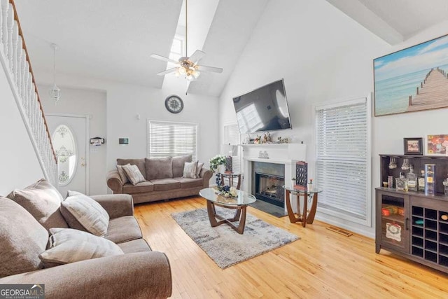 living room featuring high vaulted ceiling, ceiling fan, and light hardwood / wood-style floors