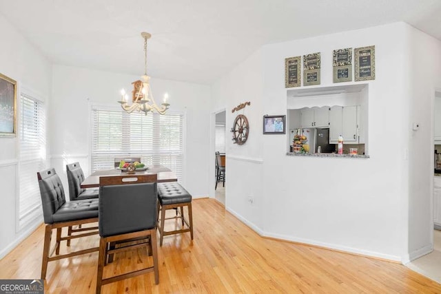 dining area featuring a notable chandelier and light hardwood / wood-style floors