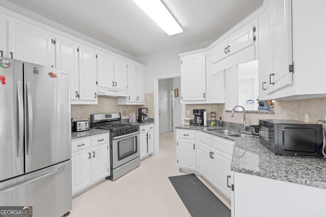 kitchen with stainless steel appliances, sink, decorative backsplash, and white cabinetry