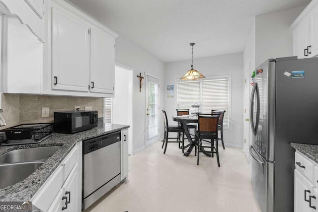 kitchen featuring pendant lighting, stainless steel appliances, decorative backsplash, and white cabinetry