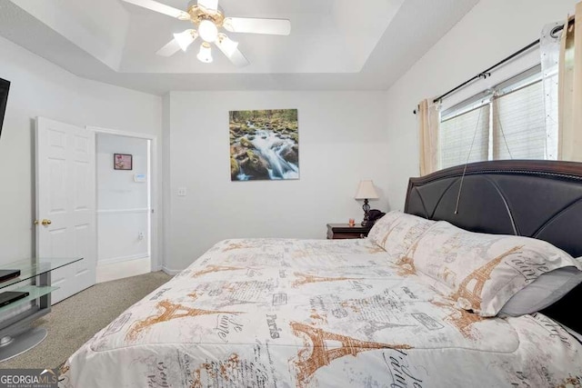 bedroom featuring carpet flooring, ceiling fan, and a tray ceiling