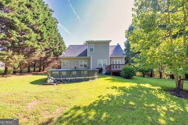 back of house featuring a yard and a pool side deck