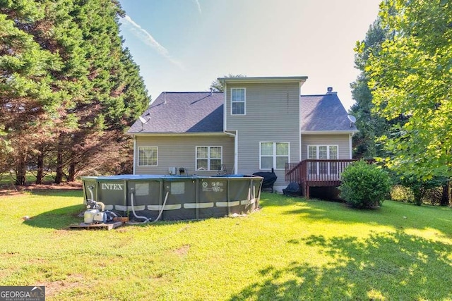 rear view of house with a pool side deck and a lawn