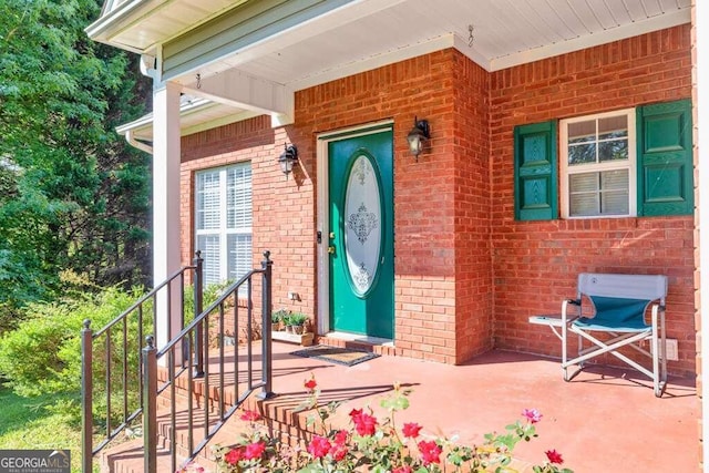 view of exterior entry featuring covered porch