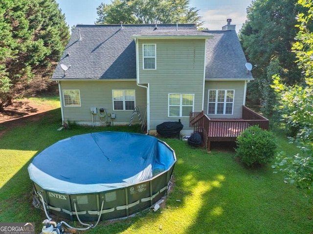 back of house with a pool side deck and a lawn