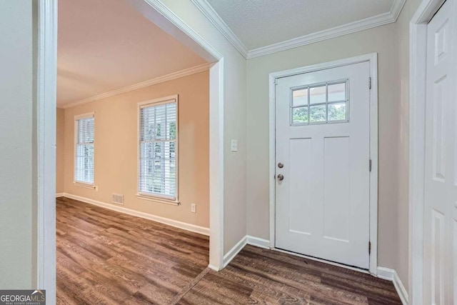 entrance foyer with dark wood-type flooring, a textured ceiling, and ornamental molding