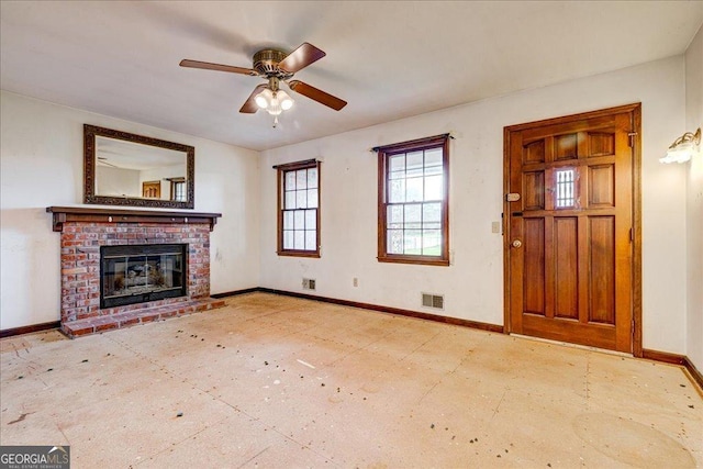 unfurnished living room with a brick fireplace and ceiling fan