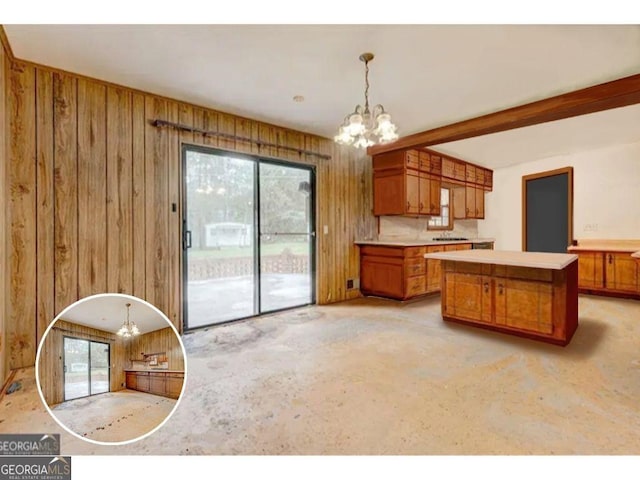 kitchen with decorative light fixtures, wooden walls, an inviting chandelier, kitchen peninsula, and beam ceiling