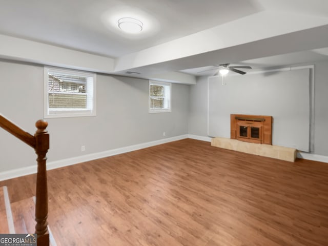 basement with a tile fireplace, hardwood / wood-style floors, and a wealth of natural light