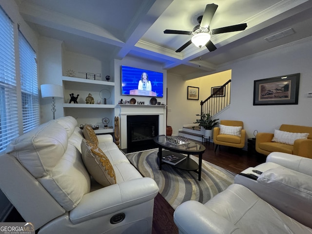 living room featuring beamed ceiling, hardwood / wood-style flooring, coffered ceiling, crown molding, and ceiling fan