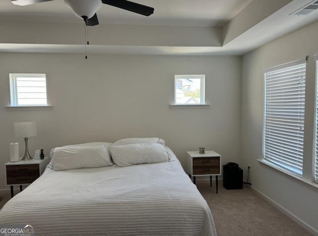 carpeted bedroom with multiple windows and ceiling fan