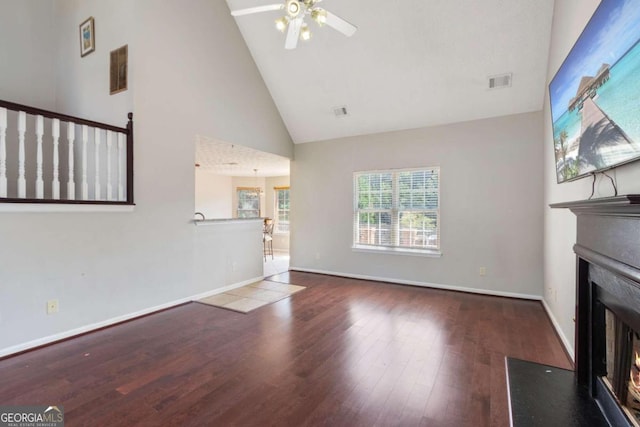 unfurnished living room featuring hardwood / wood-style floors, ceiling fan, and high vaulted ceiling