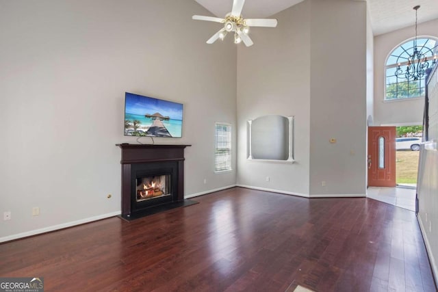 unfurnished living room with ceiling fan, dark hardwood / wood-style flooring, and high vaulted ceiling