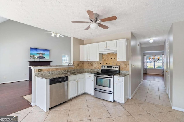 kitchen featuring appliances with stainless steel finishes, ceiling fan with notable chandelier, kitchen peninsula, and a textured ceiling