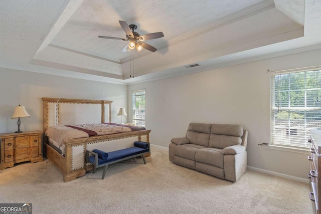 bedroom with multiple windows, a tray ceiling, and ceiling fan