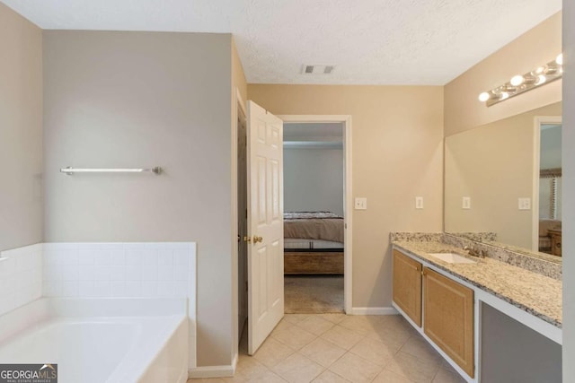 bathroom with tile patterned flooring, a textured ceiling, vanity, and a bathtub