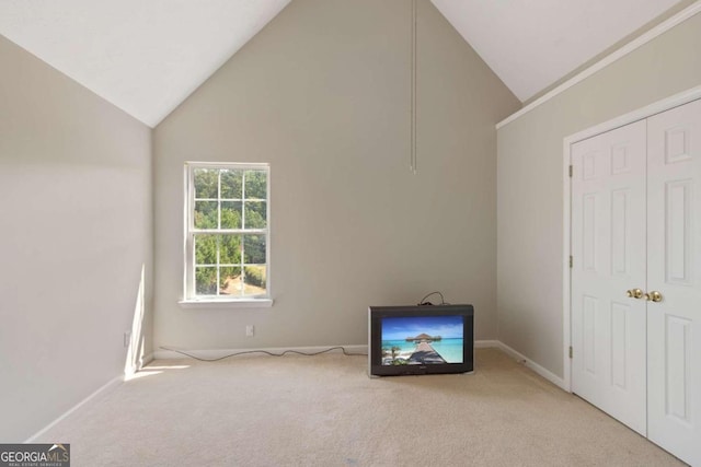 unfurnished bedroom with light carpet and high vaulted ceiling