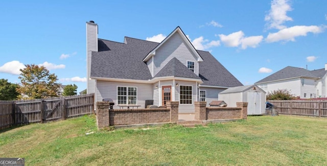 rear view of property with a storage shed and a yard