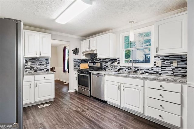 kitchen featuring hanging light fixtures, sink, white cabinets, and appliances with stainless steel finishes