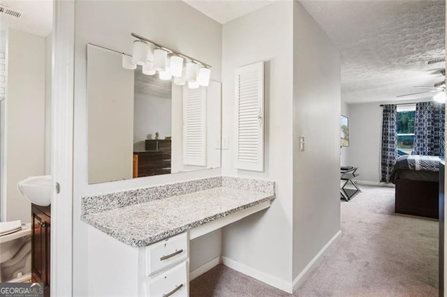 bathroom with vanity, ceiling fan, toilet, and a textured ceiling