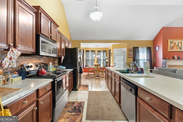 kitchen featuring pendant lighting, light tile patterned floors, stainless steel appliances, sink, and lofted ceiling