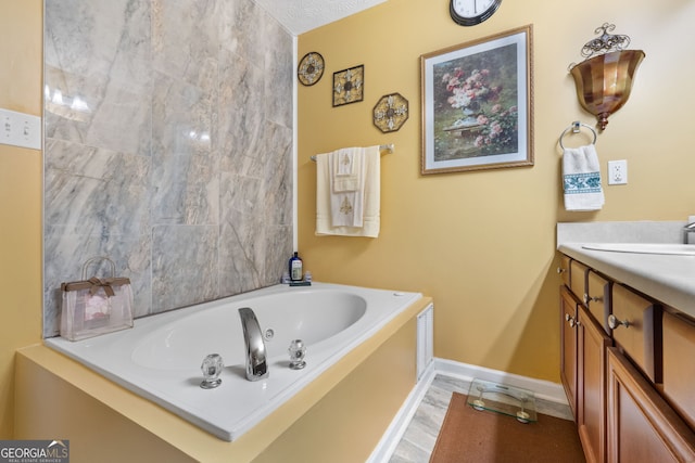 bathroom with vanity, a textured ceiling, a bathing tub, and hardwood / wood-style floors