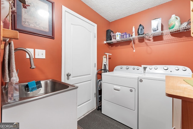 clothes washing area featuring sink, a textured ceiling, and separate washer and dryer