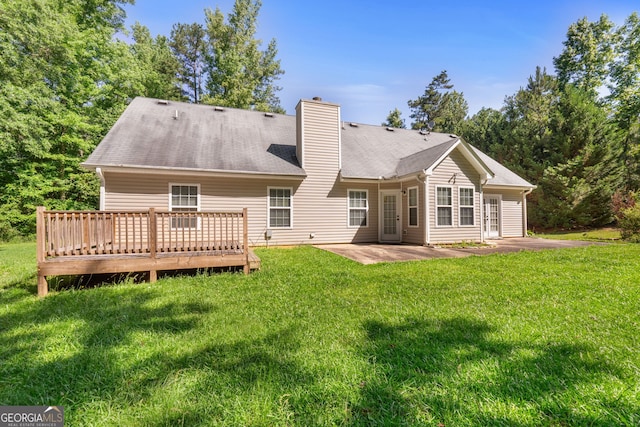 rear view of property with a patio area, a lawn, and a wooden deck