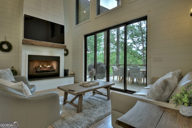 living room featuring a high ceiling and wood walls