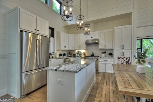 kitchen with appliances with stainless steel finishes, a healthy amount of sunlight, and white cabinets