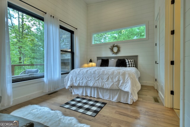 bedroom with light hardwood / wood-style flooring and multiple windows