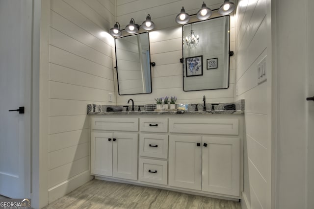 bathroom featuring wooden walls, vanity, and hardwood / wood-style floors