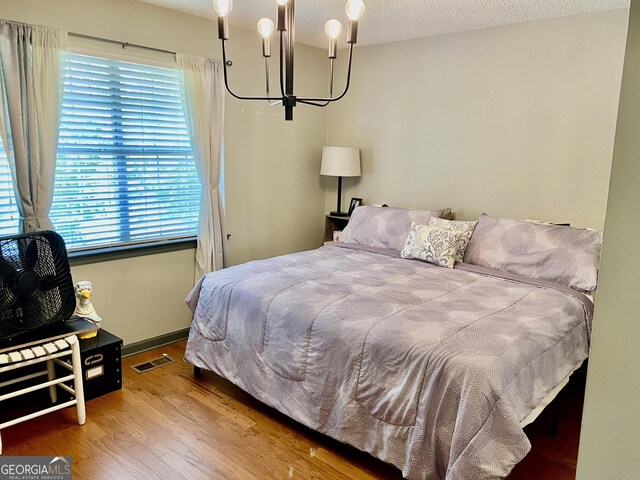 1832 Wayside Rd, Kingston, GA 30145 - bedroom with visible vents, wood finished floors, multiple windows, and an inviting chandelier