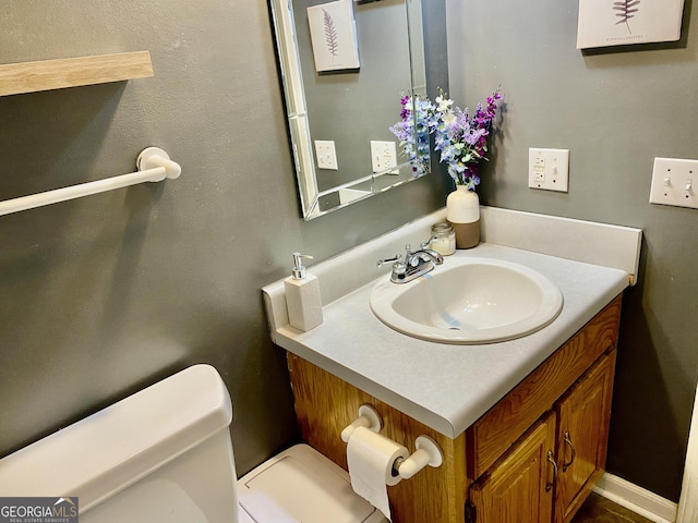 half bathroom featuring toilet and vanity
