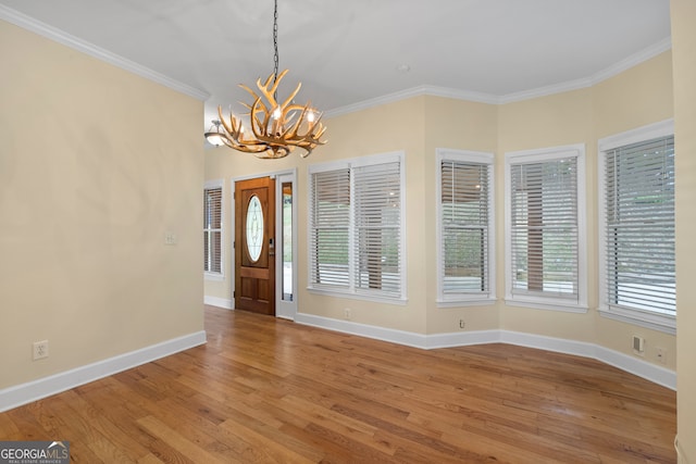 entrance foyer with ornamental molding, hardwood / wood-style floors, and a healthy amount of sunlight