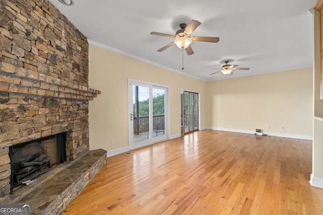 unfurnished living room with crown molding, a stone fireplace, light hardwood / wood-style flooring, and ceiling fan