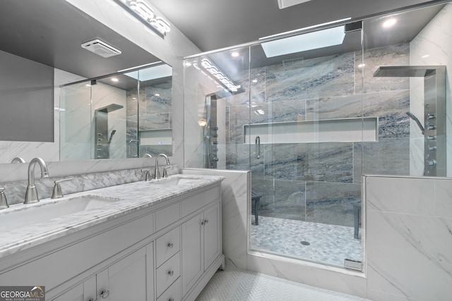 bathroom featuring vanity, tile patterned floors, a skylight, and a shower with door