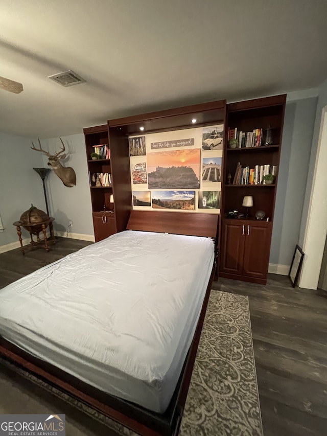 bedroom with dark hardwood / wood-style flooring