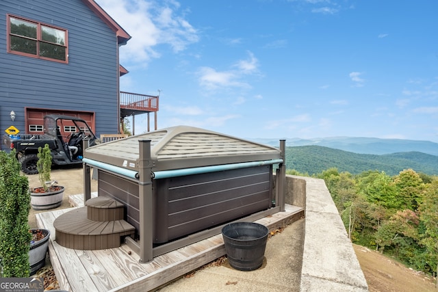 deck with a hot tub and a mountain view