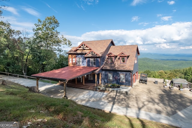 view of front of home with an outdoor structure, a mountain view, and a garage