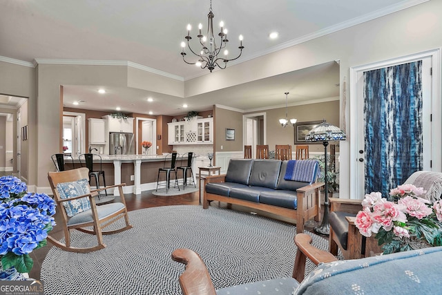 living room featuring ornamental molding, hardwood / wood-style floors, and a notable chandelier