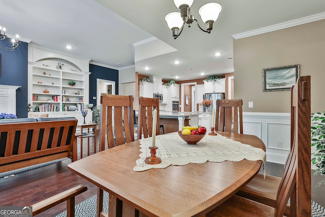 dining room featuring built in features, crown molding, dark wood-type flooring, and a chandelier