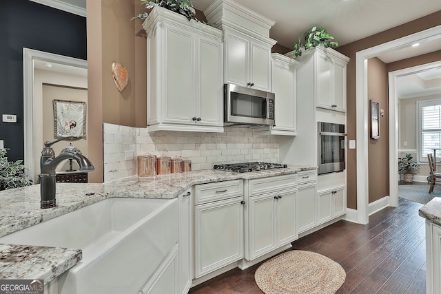 kitchen featuring light stone counters, white cabinets, sink, appliances with stainless steel finishes, and dark hardwood / wood-style flooring