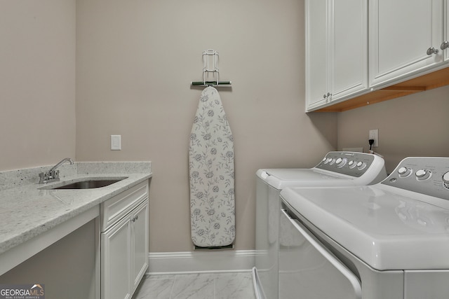 laundry area featuring separate washer and dryer, cabinets, and sink